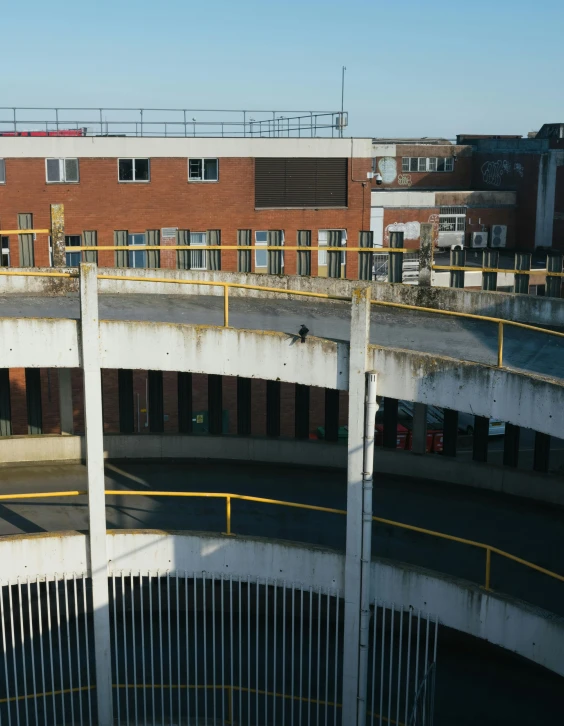 a man riding a skateboard up the side of a ramp, by Jacob Toorenvliet, brutalism, coventry city centre, parking lot, overview, round-cropped