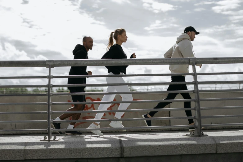 a group of people walking across a bridge, working out, modelling, profile image