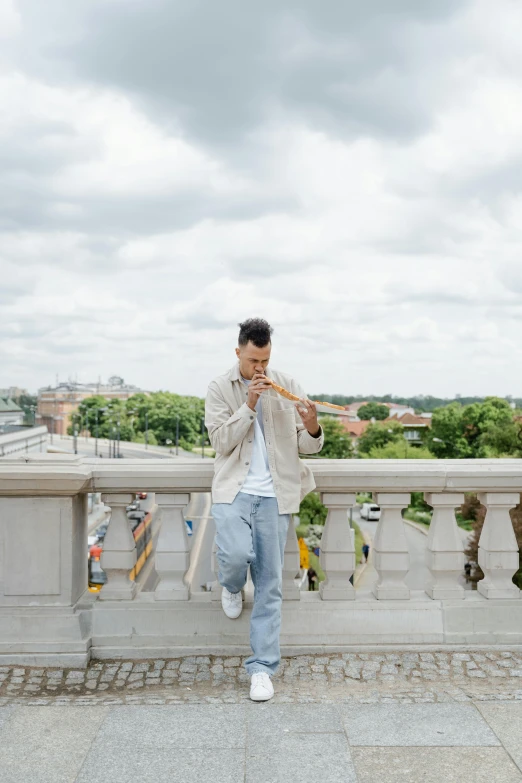 a man walking across a bridge talking on a cell phone, an album cover, by Nina Hamnett, trending on unsplash, holding a baguette, washington dc, casual pose, on rooftop