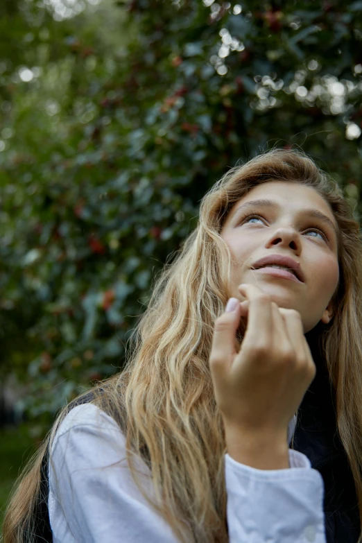 a woman looking up at an apple tree, trending on pexels, portrait of zendaya, hands in her hair. side-view, portrait sophie mudd, curly blonde hair | d & d