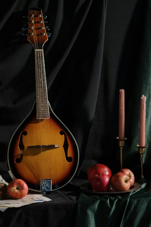 a mandolin sitting on top of a table next to apples, candle lit, background image, various posed, 2 0 1 9