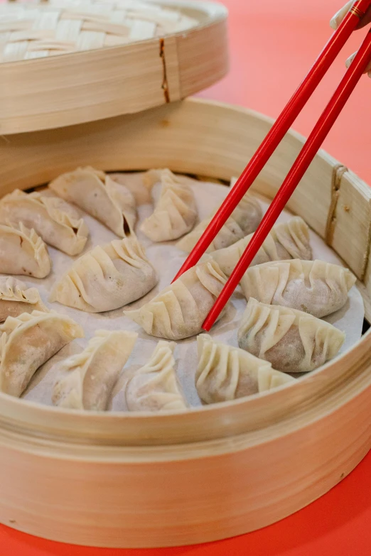 a wooden container filled with dumplings and chopsticks, reds, highly upvoted, traditional medium, humongous