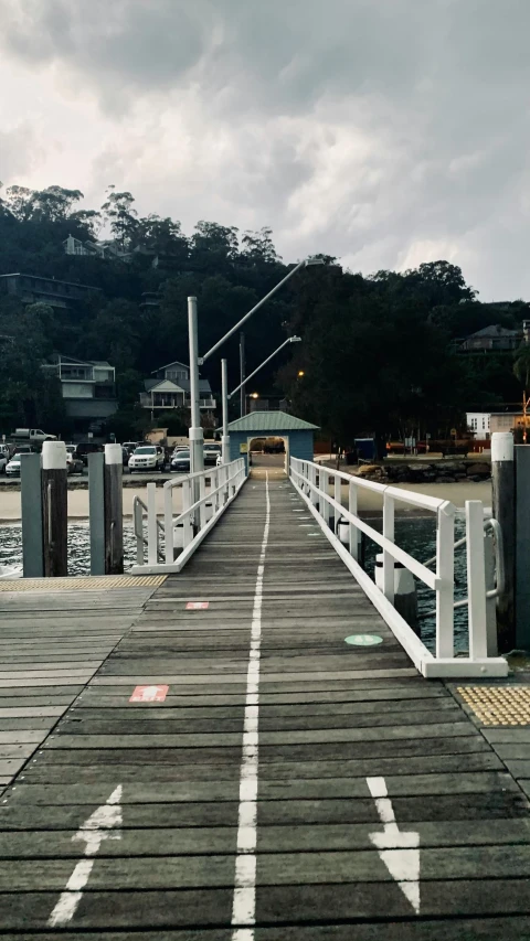 a wooden pier next to a body of water, people walking around, harbour, digital image