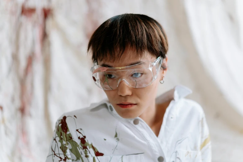 a man wearing goggles and a white shirt, a hyperrealistic painting, inspired by Fei Danxu, pexels contest winner, gutai group, experimenting in her science lab, androgynous person, painted overalls, mai anh tran