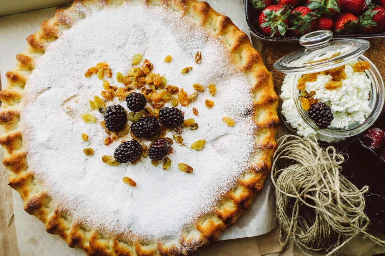 a pie sitting on top of a table next to a bowl of fruit, pexels contest winner, hurufiyya, covered in white flour, with sparkling gems on top, thumbnail, ingredients on the table