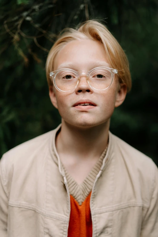 a young boy wearing glasses and an orange tie, an album cover, inspired by Oskar Lüthy, unsplash, albino, ignant, scout boy, movie still