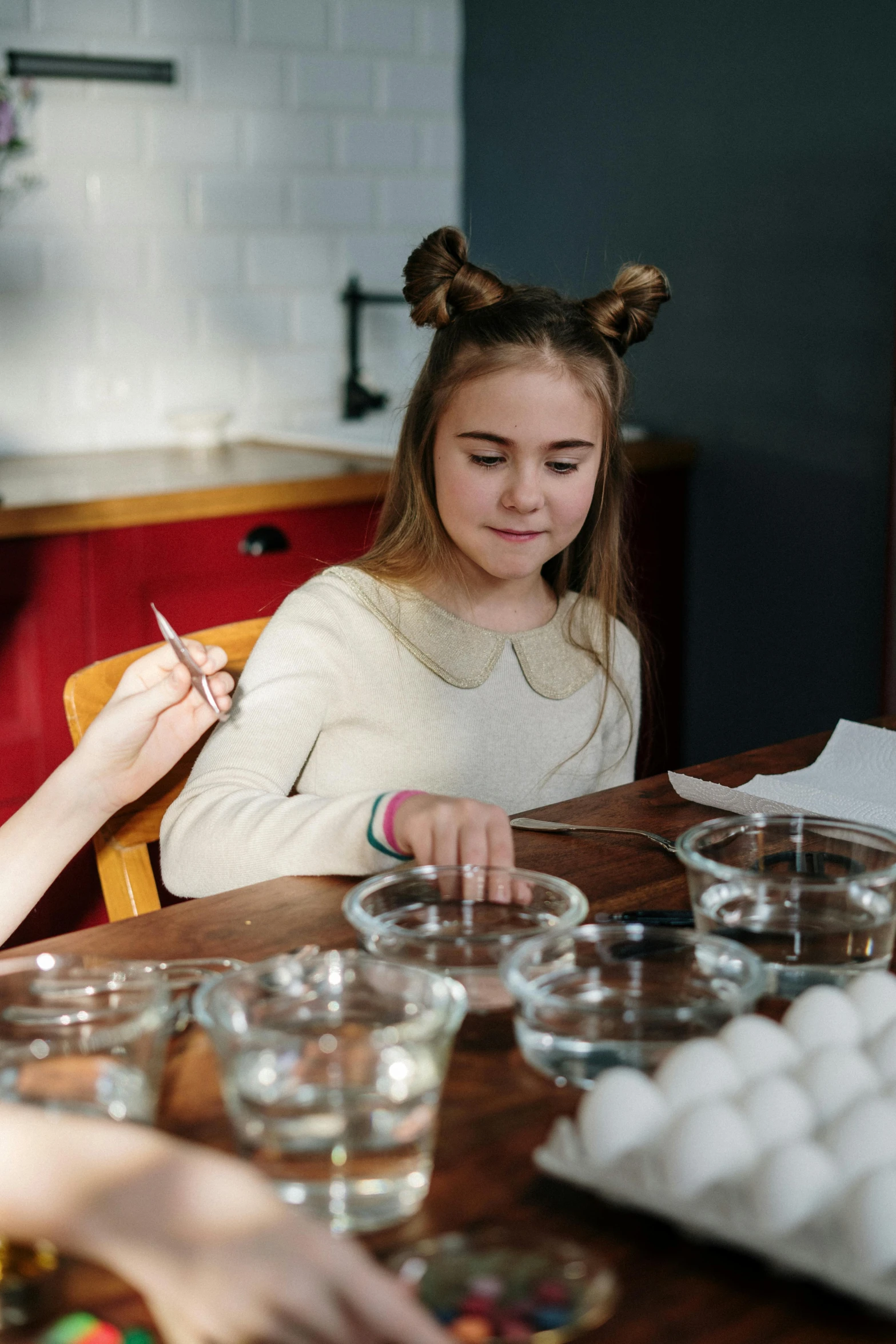 a couple of girls that are sitting at a table, pexels contest winner, process art, wizard examining eggs, on kitchen table, filling with water, studious