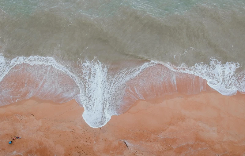 a person riding a surfboard on top of a sandy beach, pexels contest winner, minimalism, flowing salmon-colored silk, birdseye view, 15081959 21121991 01012000 4k, sea breeze rises in the air