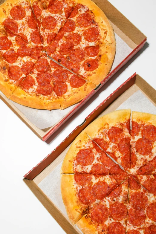 two pizzas sitting in boxes on a table, half image, 6 pack, large)}], traditional medium