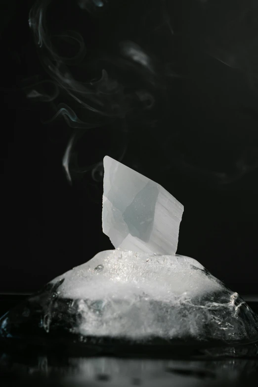 a bag of ice sitting on top of a table, inspired by Andrea Pozzo, unsplash, crystal cubism, floating in smoke, porcelain forcefield, molecular gastronomy, mezzotint