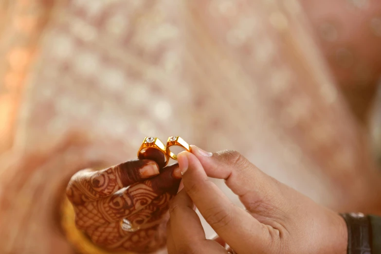 a close up of a person holding a ring, golden intricate details, thumbnail, hindu, brown