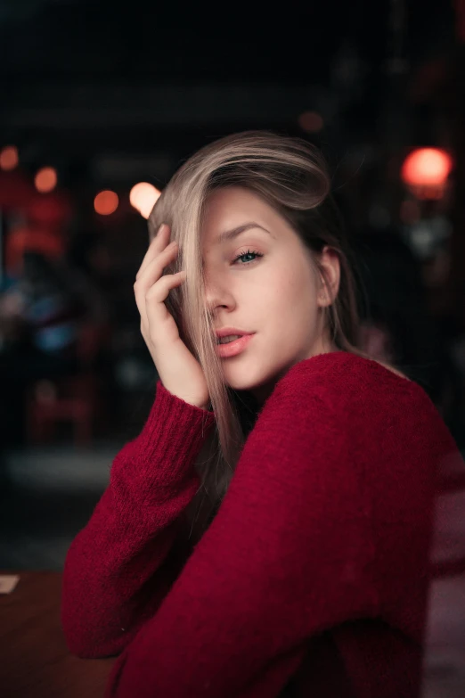 a woman in a red sweater sitting at a table, a picture, inspired by Elsa Bleda, trending on pexels, sexy face, anna nikonova aka newmilky, gif, soft hair