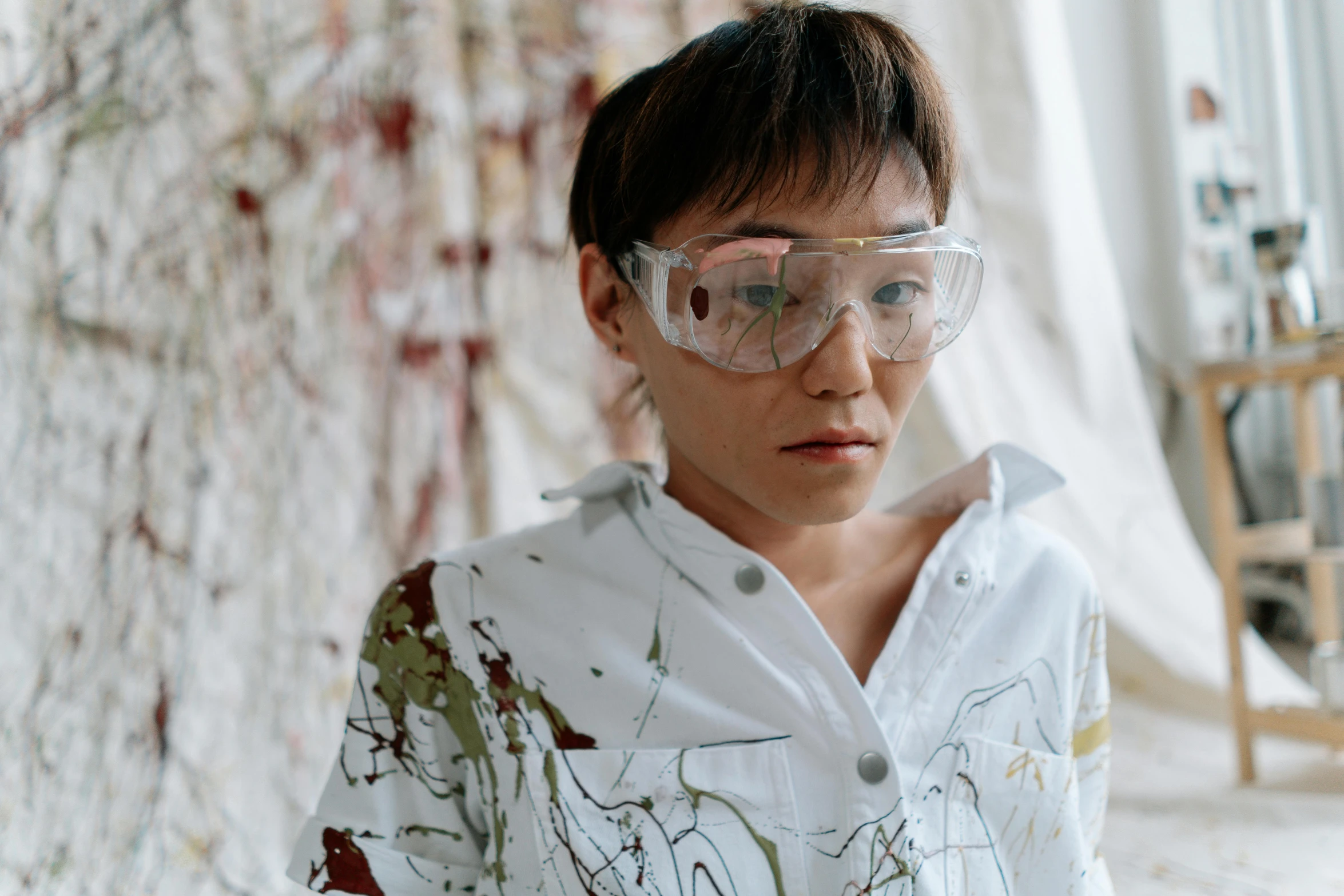 a boy with paint all over his shirt and goggles, a hyperrealistic painting, inspired by Cecily Brown, trending on pexels, portrait of a female pathologist, androgynous person, glass studio, a young asian woman