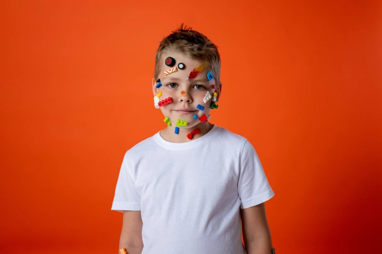 a young boy with sprinkles on his face, inspired by Damien Hirst, pexels contest winner, robot face bust, avatar image, legos, full body image
