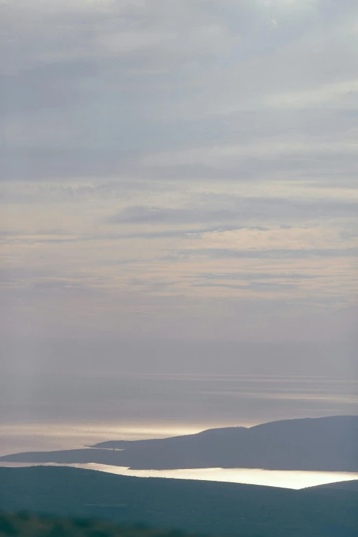 a person riding a snowboard on top of a snow covered slope, inspired by Andreas Gursky, soft lilac skies, orkney islands, colour photograph, late summer evening