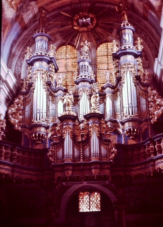 a large pipe organ sitting inside of a building, an album cover, flickr, baroque, majestic spires, taken in the early 1970s, shiny gold, 1960s color photograph