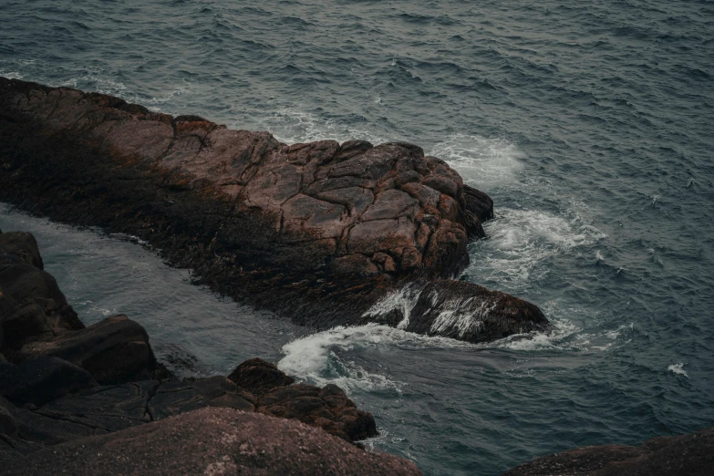 a large body of water next to a rocky shore, pexels contest winner, australian tonalism, lo fi, ((rocks)), brown, album cover