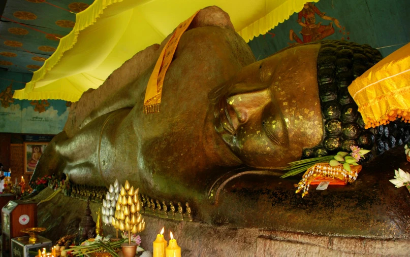 a close up of a statue of a person with an umbrella, in a temple, lie on a golden stone, nuttavut baiphowongse, avatar image