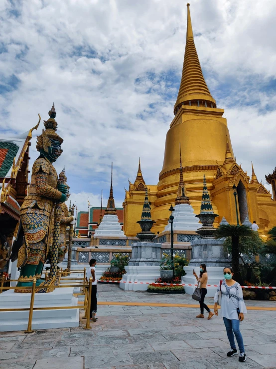 a group of people that are standing in front of a building, thai architecture, parks and monuments, gold, profile image