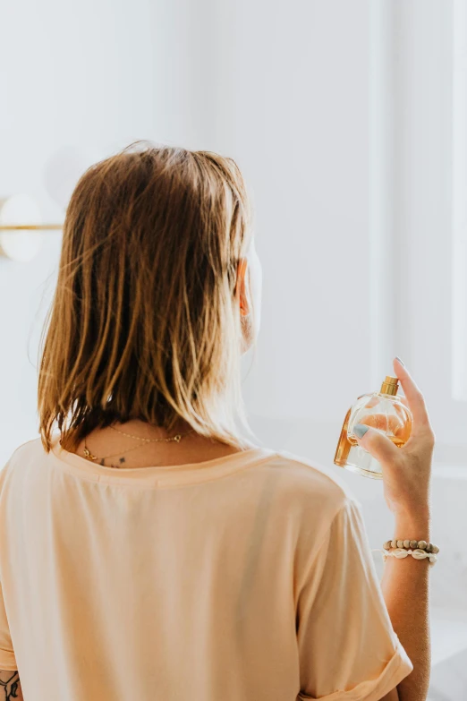 a woman standing in front of a mirror brushing her teeth, by Nicolette Macnamara, trending on pexels, renaissance, carrying a bottle of perfume, photographed from the back, wearing a light shirt, full of golden layers