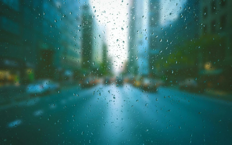 a city street is seen through a rain covered window, an album cover, inspired by Elsa Bleda, unsplash contest winner, visual art, blue blurred, green rain, water drops on the lense, rainy day in minecraft