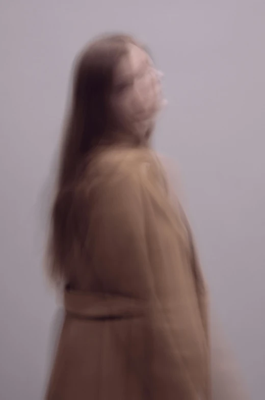 a blurry photo of a woman with long hair, inspired by Anna Füssli, conceptual art, ( ( wearing a long coat ) ), dehazed image, ignant, studio photo