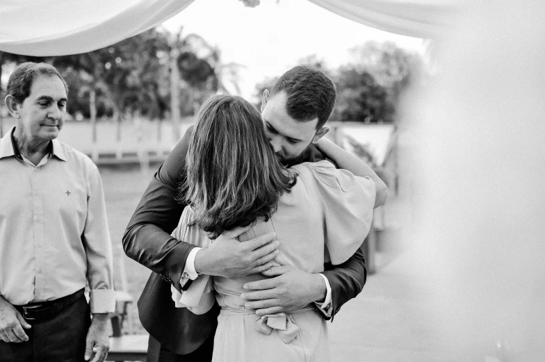 a couple of people that are hugging each other, a black and white photo, mateo dineen, celebration, item, featured