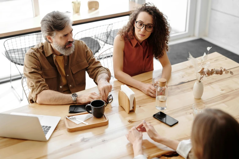 a group of people sitting around a wooden table, profile image, selling insurance, thumbnail