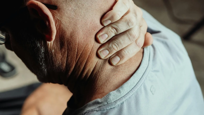 a man with his hand on his neck, profile image, recovering from pain, zoomed in, an oldman
