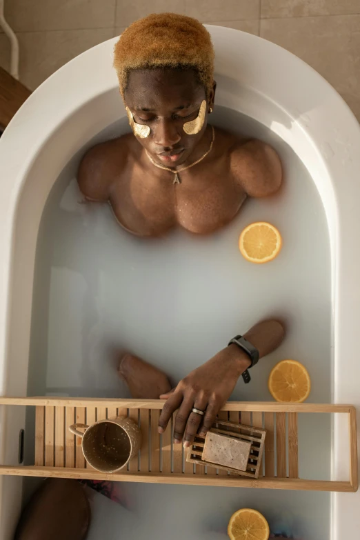 a man that is sitting in a bath tub, by Jessie Alexandra Dick, trending on pexels, renaissance, african steampunk alchemist, top down shot, clean shaven, lemonade