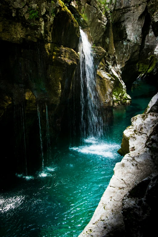 a man standing in front of a waterfall, by Franz Hegi, pexels contest winner, romanticism, turquoise water, inside a gorge, slovenian, panoramic