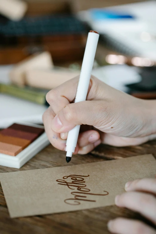 a close up of a person writing on a piece of paper, brown and white color scheme, gourmet and crafts, thumbnail, packaging