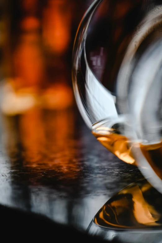 a close up of a wine glass on a table, by Adam Marczyński, pexels contest winner, renaissance, drinks bourbon, zoomed in, multi-dimensional, bar background