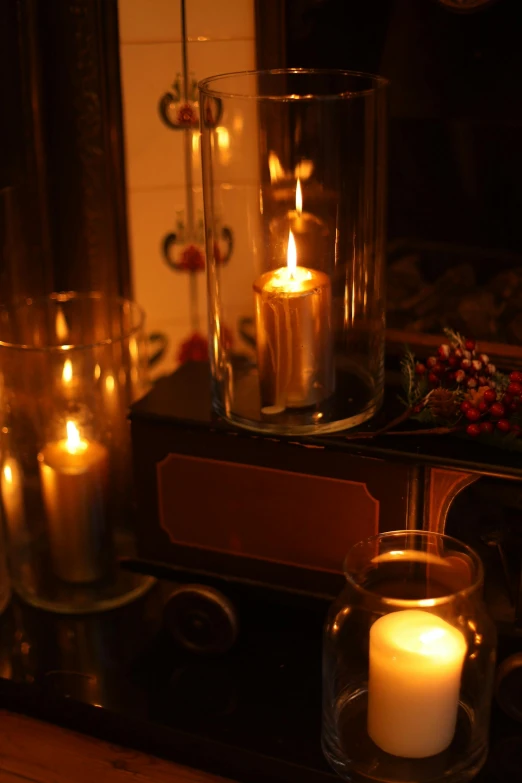 a group of candles sitting on top of a table, inspired by Joseph Wright of Derby, romanticism, warm lantern lighting, nixie tube, cosy fireplace, up close shot