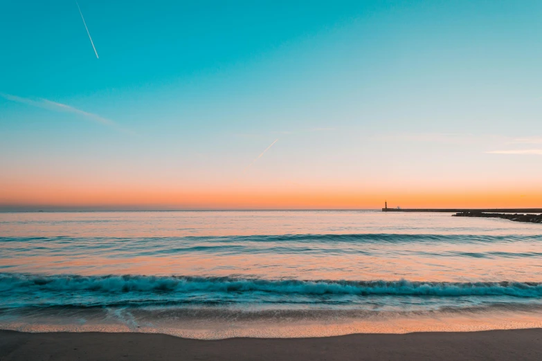 a large body of water next to a beach, pexels contest winner, blue sky at sunset, rocket launching into the sky, striped orange and teal, minimalist environment