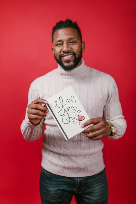 a man holding up a card that says i love you, an album cover, inspired by Valentine Hugo, pexels contest winner, holding notebook, jamal campbell, vertical portrait, ray lewis