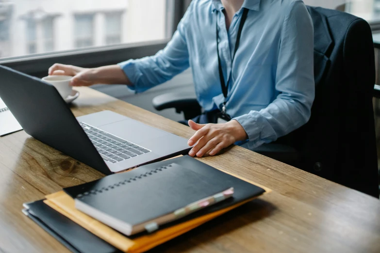 a man sitting at a desk using a laptop computer, by Carey Morris, pexels, wearing business casual dress, zoomed in, avatar image, schools