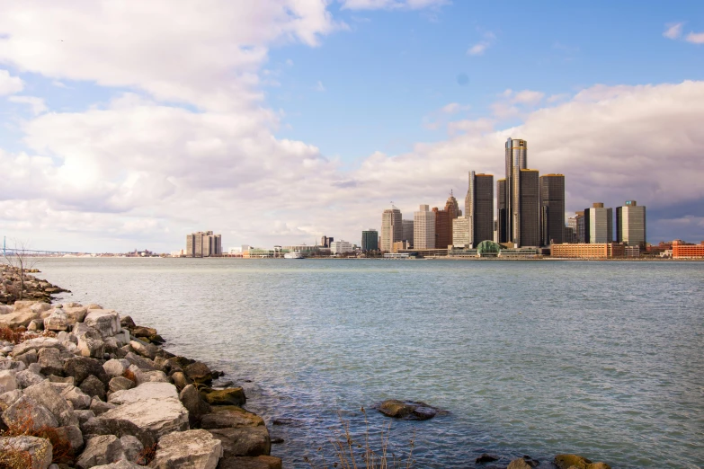 a large body of water with a city in the background, by Greg Rutkowski, pexels contest winner, michigan, slide show, shoreline, afternoon