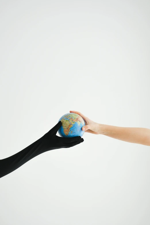 a person holding a small globe in their hand, an album cover, by Gavin Hamilton, trending on pexels, two people, prosthetic arm, black, 15081959 21121991 01012000 4k