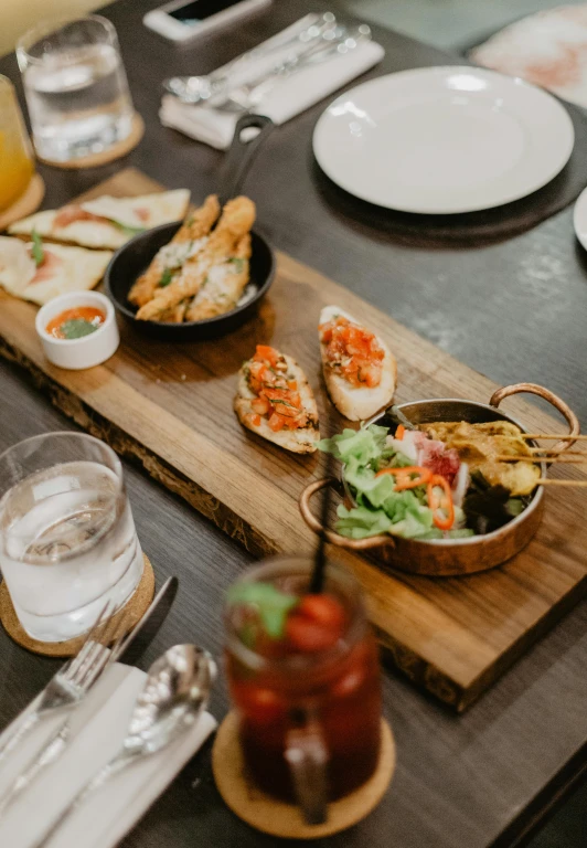 a wooden table topped with plates of food, unsplash, dynamic closeup, sparkling, daily specials, high quality picture