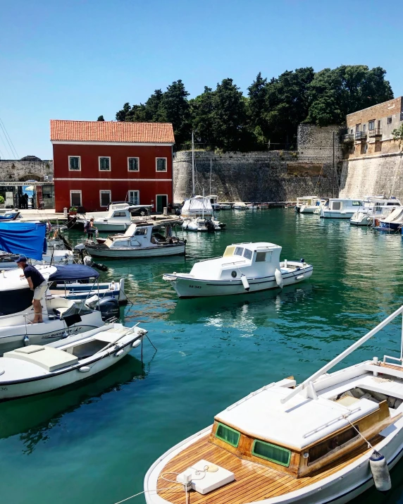 a number of boats in a body of water, a picture, pexels contest winner, renaissance, whitewashed buildings, red castle in background, boka, thumbnail