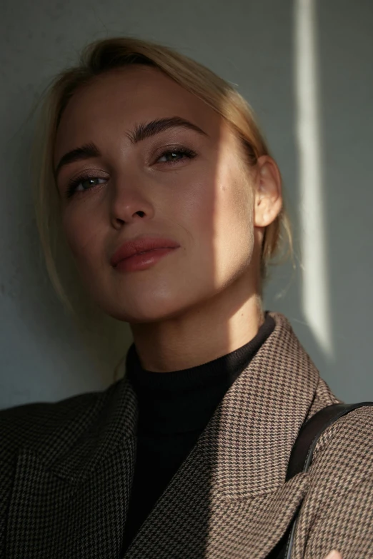 a woman with a handbag leaning against a wall, inspired by Emma Andijewska, trending on pexels, photorealism, round jawline, yvonne strahovski, wearing a turtleneck and jacket, selfie photo