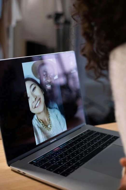 a woman sitting in front of a laptop computer, a picture, by Julia Pishtar, trending on pexels, close together, webcam screenshot, glossy surface, diverse