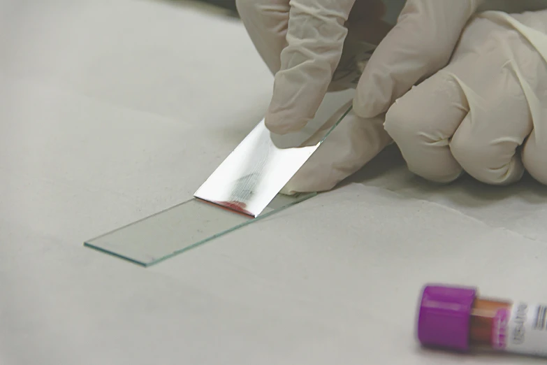 a person cutting a piece of glass with a pair of gloves, biomaterial, 40mm tape, rectangle, enamel