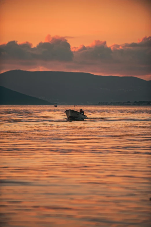 a boat in a body of water with mountains in the background, by Sven Erixson, pexels contest winner, happening, sunset colors, croatian coastline, hunting, split near the left