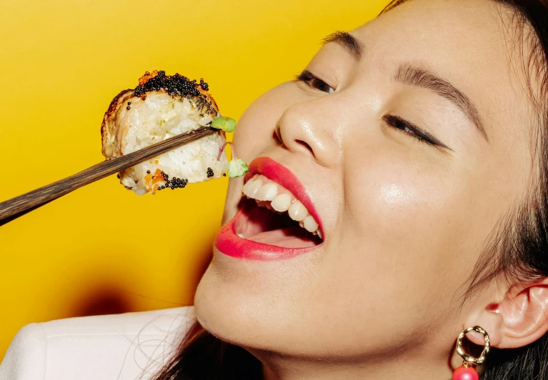 a woman eating sushi with a pair of chopsticks, by Julia Pishtar, with gold teeth, louise zhang, extra crisp image, thumbnail