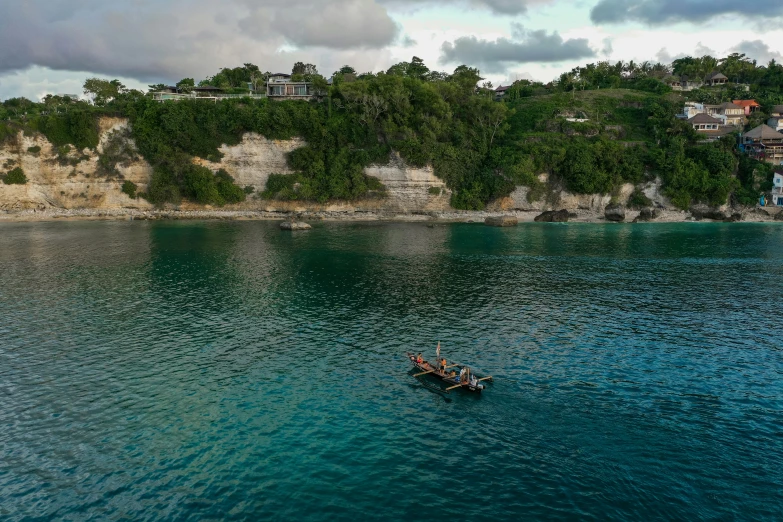 a couple of people in a small boat on a body of water, by Simon Marmion, pexels contest winner, the village on the cliff, indonesia national geographic, jamaica, 2022