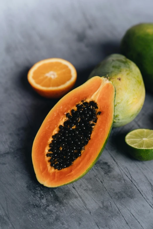 a bunch of fruit sitting on top of a table, orange and black, tropical undertones, seeds, soft chin