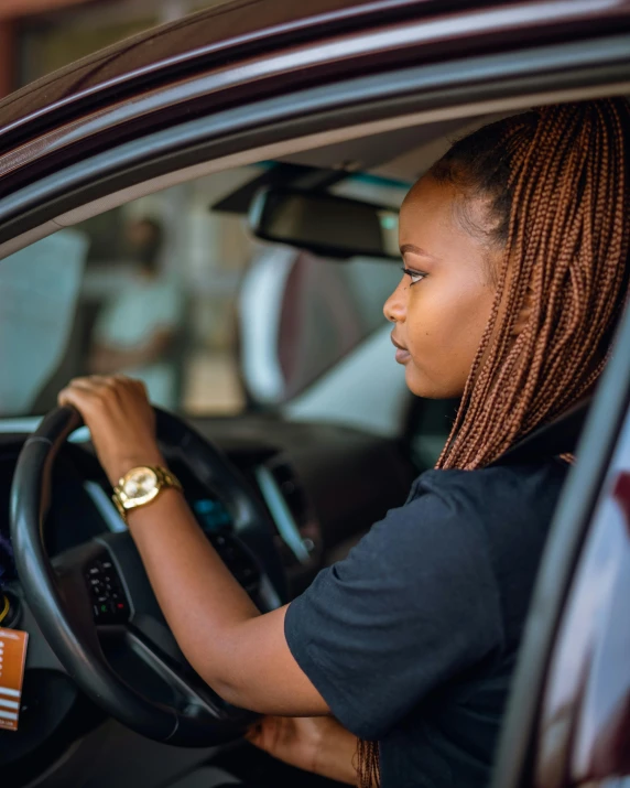 a woman sitting in the driver's seat of a car, trending on unsplash, patron saint of 🛸🌈👩🏾, square, standing sideways, profile image