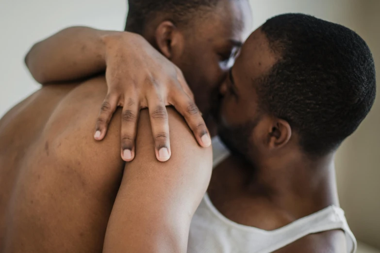 a man giving a woman a kiss on the cheek, by Matija Jama, trending on pexels, two muscular men entwined, couple on bed, godwin akpan, holding each other hands